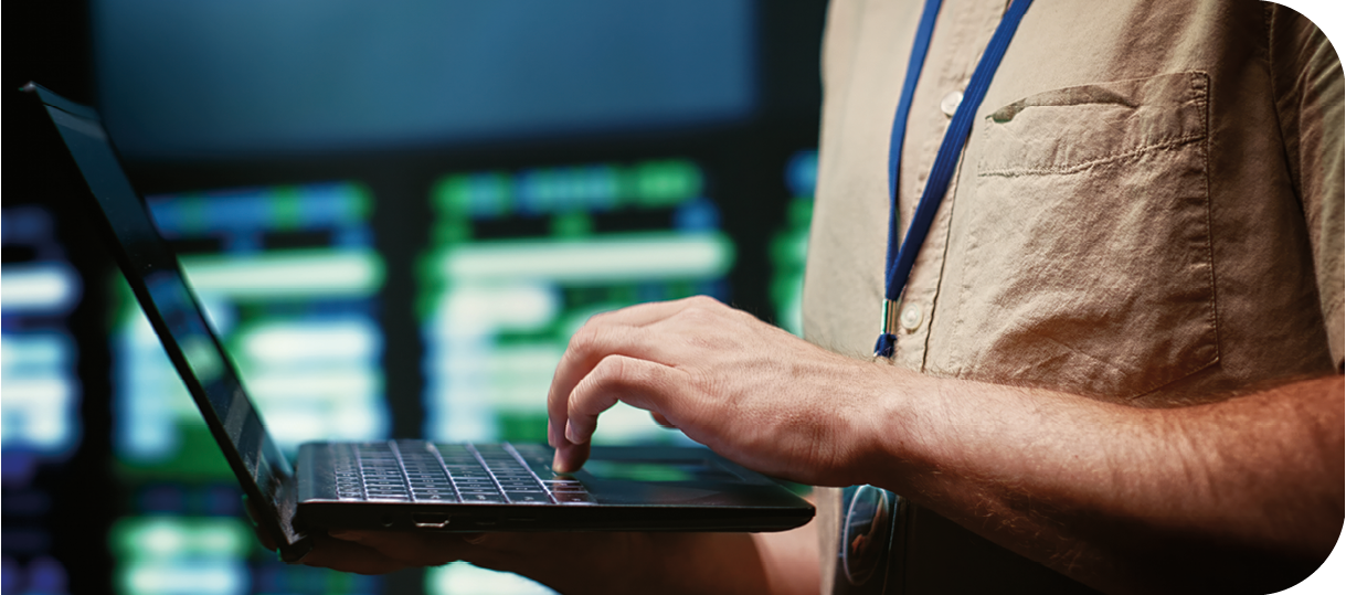 IT developer using laptop to monitor server farm security to protect information access, making sure virus protection software is updated and hackers trying to penetrate systems are rejected, close up
