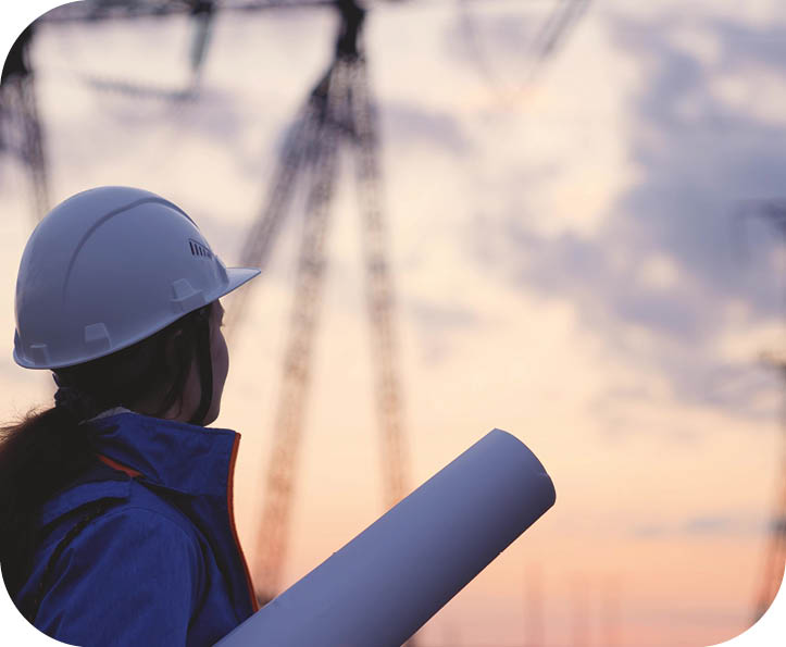 An electrician at a high voltage power plant works with a project at sunset in the sky, electrical energy design, industry concept, modern business technology, an engineer in the glare of the sun.