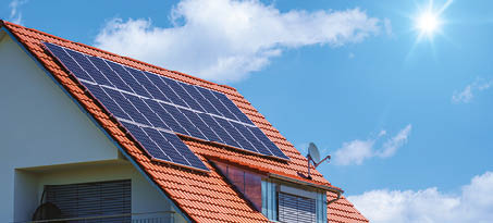 An image of a home with solar energy green plants and sunny blue sky